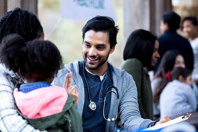 Primary Care physician talking with mother and child.